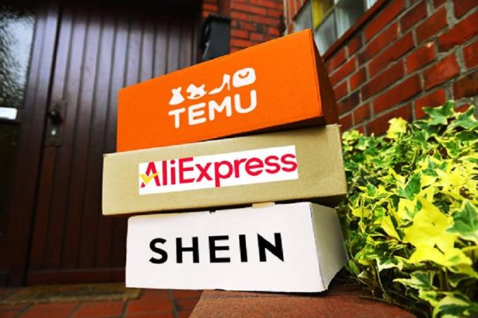 FOTOMONTAGE, Gestapelte Pakete von den chinesischen Versandhändlern Temu, AliExpress und Shein in einem Hauseingang ***